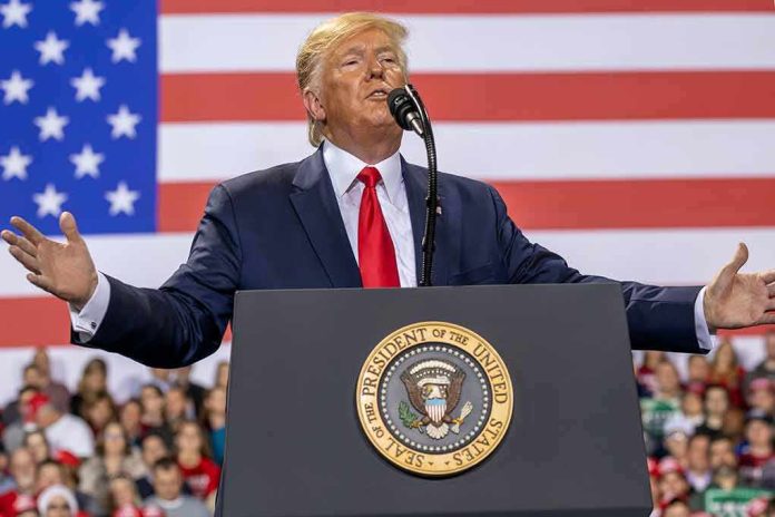shutterstock_1677446302 Donald Trump speaks at a podium with U.S. flag backdrop; Christian Jones, Caraun Reid, and Bill Bergey in crowd