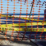 Mysterious Orbs Found Scattered Along Beach Orange safety net and yellow police tape blocking a beach access