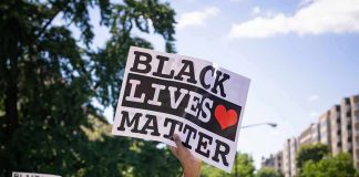 protester holding a Black Lives Matter sign at a daytime march
