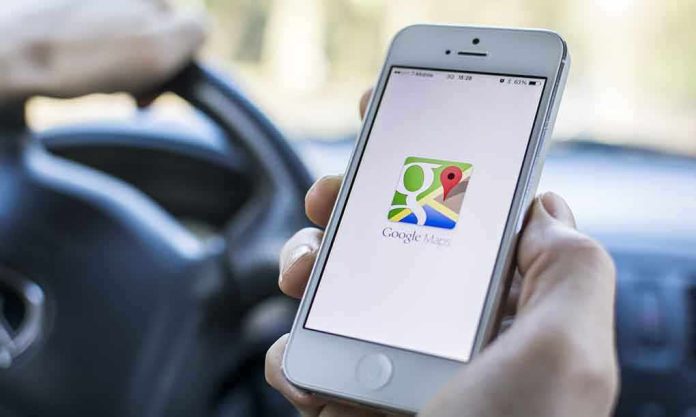 A person holding a smartphone displaying the Google Maps app while driving