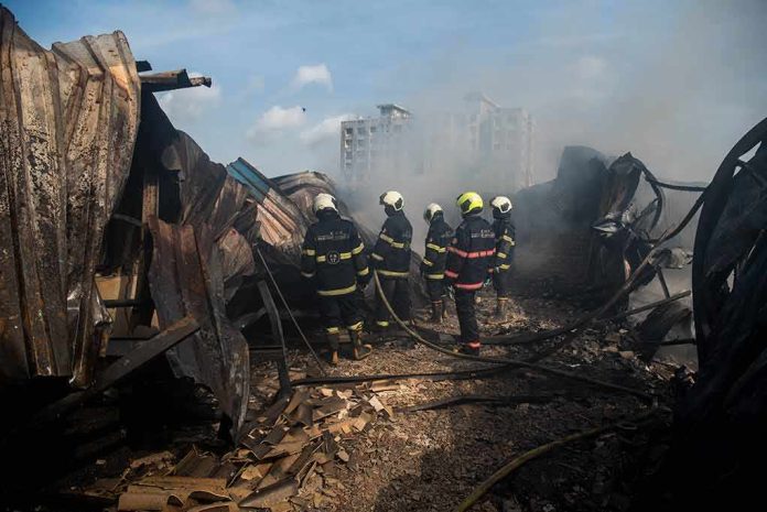 Firefighters amid twisted metal and smoke at a disaster site