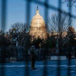 U.S. Capitol behind security fencing and guards on a street