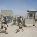 Trump PULLS Troops From Baghdad, Closes Final Chapter Soldiers in desert uniforms run past a checkpoint amid dust