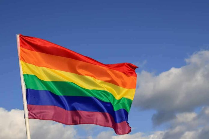 shutterstock_1932442001 Rainbow pride flag waving against a blue sky