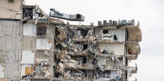 Partially collapsed apartment building with exposed rooms and debris