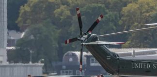 Motorcade and helicopter on a waterfront helipad