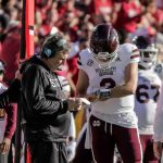 Blacks Athletes BOYCOTT Southern State Schools! Mississippi State football coach and quarterback review play card on sideline