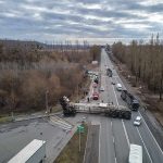 Overturned semi-trailer blocks highway at rural intersection