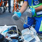Two Dead Bodies At Burning Man Paramedic kneeling with defibrillator paddles