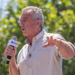 Man speaking into a microphone outdoors