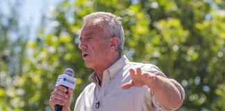 RFK Flies $9,000 an Hour Jet To Attend Conference Man speaking into a microphone outdoors