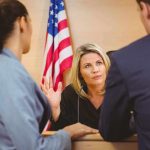 Candace Owens in Contempt of Court – Ignored Subpoenas Judge speaking with two attorneys at the bench in a courtroom