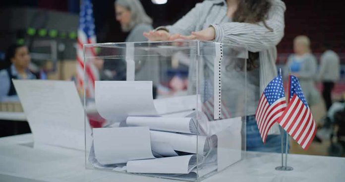 Person casting a ballot into a clear box at a polling station