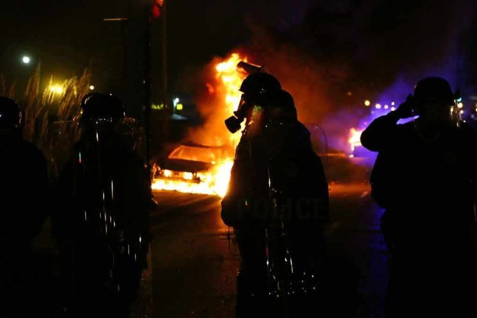 shutterstock_250958185 Riot police stand near burning cars at night