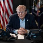 Trump Tells Americans to Pay Their Fair Share Person in suit seated at table with telephones
