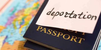 Stack of passports with a note labeled deportation on top, placed on a map