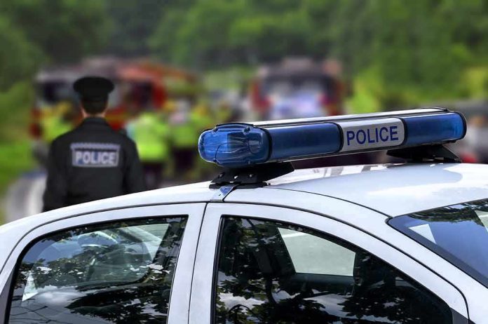 shutterstock_299407196 Police car with blue light bar at roadside scene