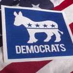 Dem Rep Hires KNOWN Sex-Offender For Top Office Role Democrats donkey symbol on a blue sign over an American flag