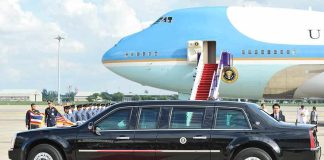 Presidential limousine beside a large blue-and-white jet on a runway