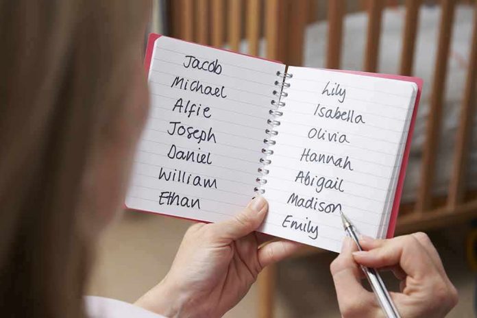 shutterstock_345850001-1 Hands holding a notebook with baby name lists near a crib