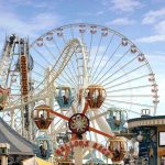 Colorful amusement park scene featuring a ferris wheel and carousel