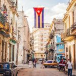 Cuban flag over colorful old Havana street
