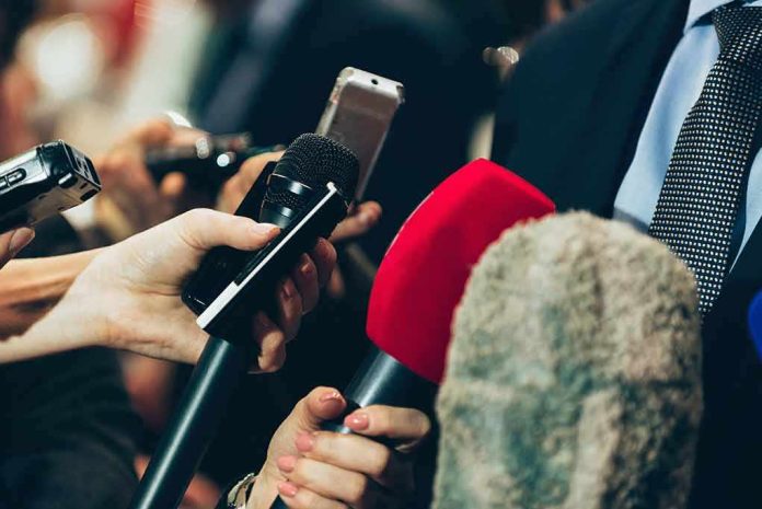 Microphones held up to a speaker in a suit