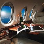 NEW Air Force One Takes Maiden Flight! private jet cabin with leather seat, champagne and magazine on table