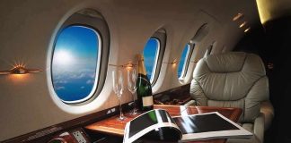 private jet cabin with leather seat, champagne and magazine on table
