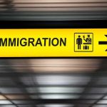 ICE Joins Forces With Iran Amid War Immigration sign with arrow in airport