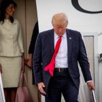 Air Force One Swap Sparks Media Brawl man in suit with red tie walking down airplane stairs