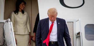 Air Force One Swap Sparks Media Brawl man in suit with red tie walking down airplane stairs