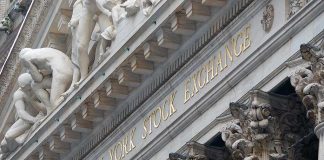 Facade of the New York Stock Exchange featuring sculptures and gold lettering