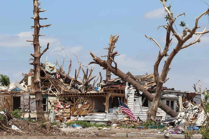 Storm-damaged house with fallen trees and debris