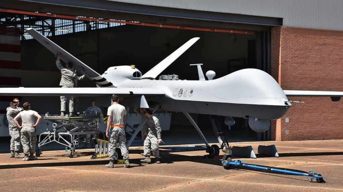 shutterstock_1079246960 Military drone being serviced by ground crew outside a hangar