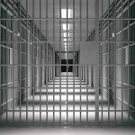 empty prison corridor with barred cells
