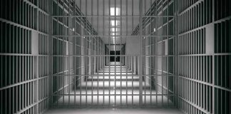 empty prison corridor with barred cells