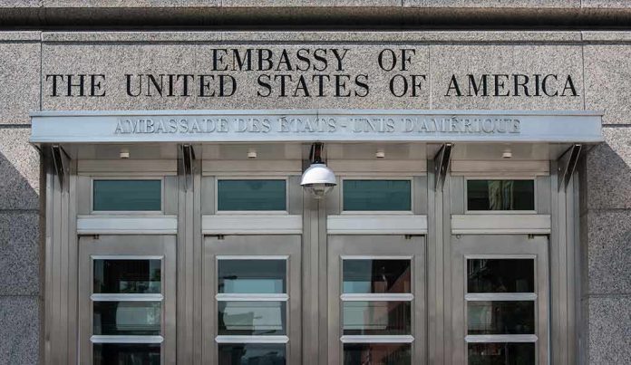United States embassy entrance with metal doors and security camera