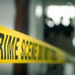 crime scene tape in a blurred indoor setting