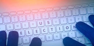 Gloved hands typing on a keyboard with highlighted election keys