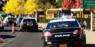 Hero Bystander GUNS DOWN School Shooter Police cars with lights on near school buses on a city street