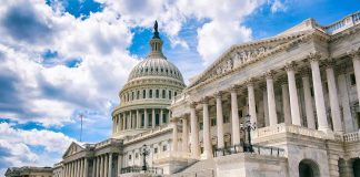 United States Capitol building with dome and columns under a partly cloudy sky