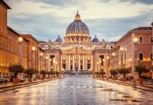 St. Peter's Basilica at the end of a wet street at dusk
