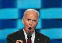 man in suit speaking passionately at a podium