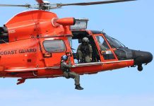 Rescue helicopter with crew performing hoist operation