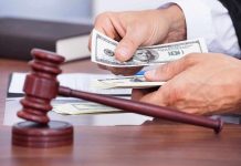 A person counting cash in a courtroom setting with a gavel in the foreground