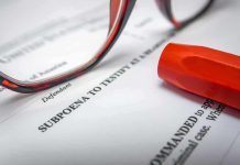 Subpoena document with red highlighter and eyeglasses