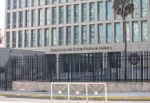 Embassy building behind tall black security fence