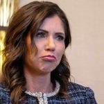 Woman with wavy brown hair making a pouting expression