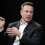 Musk Appointed TOP Pentagon Role – Even Gets an Office Elon Musk speaking in a black suit against a dark background